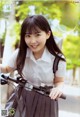 A young woman riding a bike on a city street.