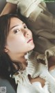 A woman laying on top of a bed covered in a blanket.