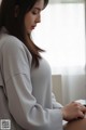 A woman sitting at a table looking out a window.