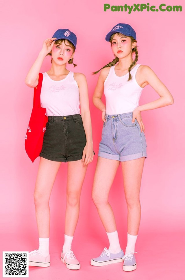 Two young women standing next to each other on a pink background.