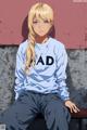 A girl sitting on a bench wearing a sweatshirt that says MAD.