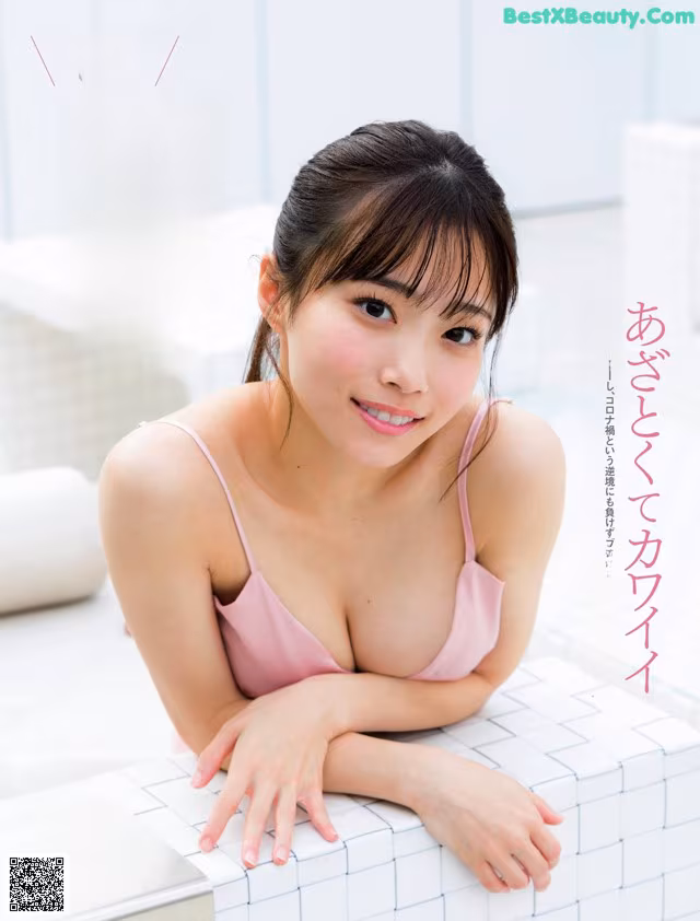 A woman in a pink bra sitting on a white bench.
