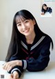 A woman in a school uniform sitting at a table.