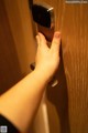 A person's hand is pressing a door handle.