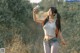 A woman in shorts and a tank top holding a water bottle.