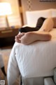 A woman laying on a bed with her feet up.