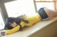 A woman in a yellow shirt and black stockings laying on a window sill.