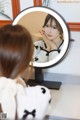 A woman is looking at her reflection in a mirror.