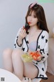 A woman sitting on a chair eating a bowl of fruit.