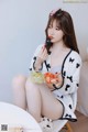 a woman sitting on a chair eating a bowl of fruit